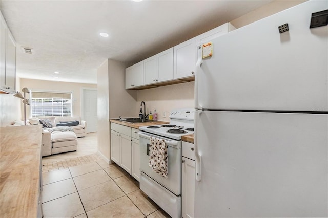 5101 13th Ave S, Gulfport, FL 33707 - kitchen featuring a sink, white cabinets, light tile patterned flooring, and white appliances