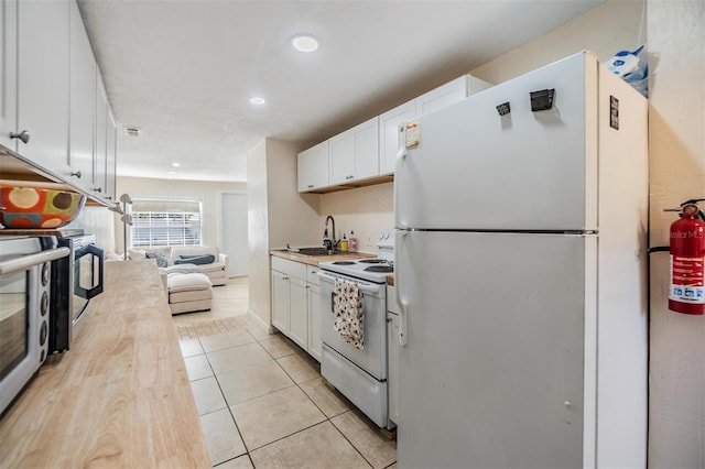 5101 13th Ave S, Gulfport, FL 33707 - kitchen featuring white appliances, white cabinets, a sink, and light countertops