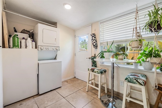 5101 13th Ave S, Gulfport, FL 33707 - washroom with light tile patterned flooring, baseboards, and stacked washer / dryer