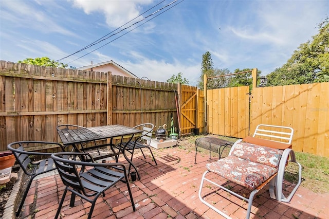 5101 13th Ave S, Gulfport, FL 33707 - view of patio with outdoor dining area, a gate, and a fenced backyard