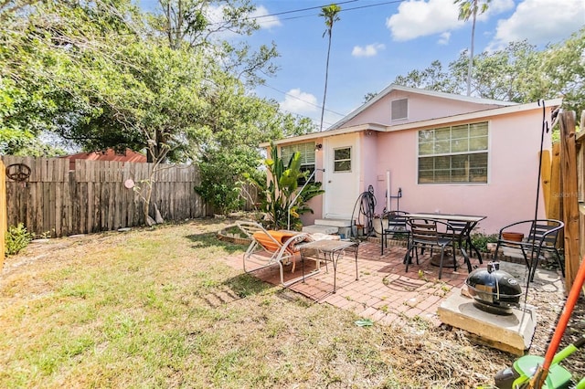 5101 13th Ave S, Gulfport, FL 33707 - back of property featuring a yard, a patio, a fenced backyard, and stucco siding