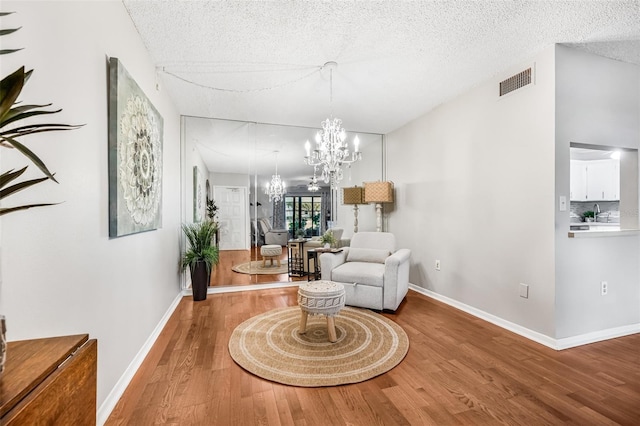 1281 Pine Ridge Cir E Unit H1, Tarpon Springs, FL 34688 - sitting room featuring visible vents, baseboards, wood finished floors, and an inviting chandelier