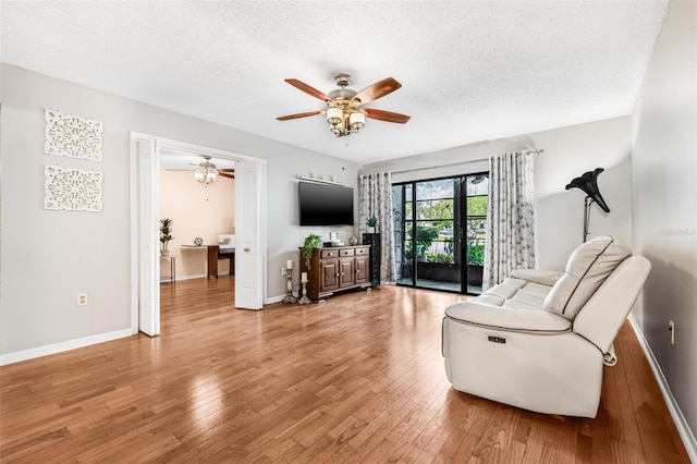 1281 Pine Ridge Cir E Unit H1, Tarpon Springs, FL 34688 - living area with baseboards, ceiling fan, light wood-type flooring, and a textured ceiling