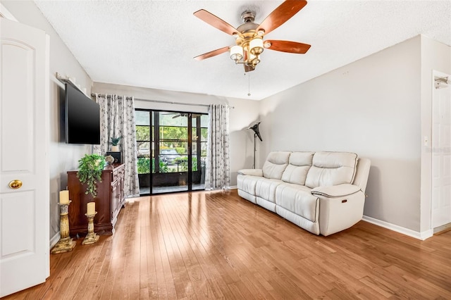 1281 Pine Ridge Cir E Unit H1, Tarpon Springs, FL 34688 - living area with baseboards, a textured ceiling, wood-type flooring, and ceiling fan