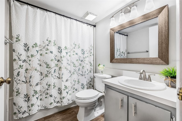 1281 Pine Ridge Cir E Unit H1, Tarpon Springs, FL 34688 - full bath featuring vanity, toilet, wood finished floors, shower / tub combo, and visible vents