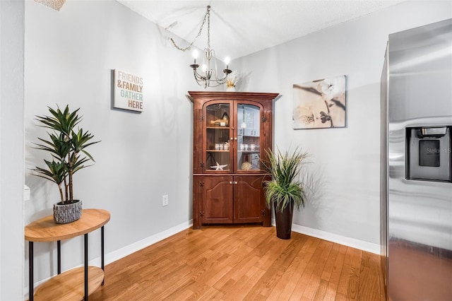 1281 Pine Ridge Cir E Unit H1, Tarpon Springs, FL 34688 - interior space featuring baseboards, an inviting chandelier, and light wood finished floors