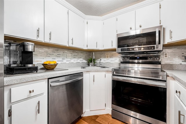 1281 Pine Ridge Cir E Unit H1, Tarpon Springs, FL 34688 - kitchen with a sink, light countertops, a textured ceiling, stainless steel appliances, and backsplash
