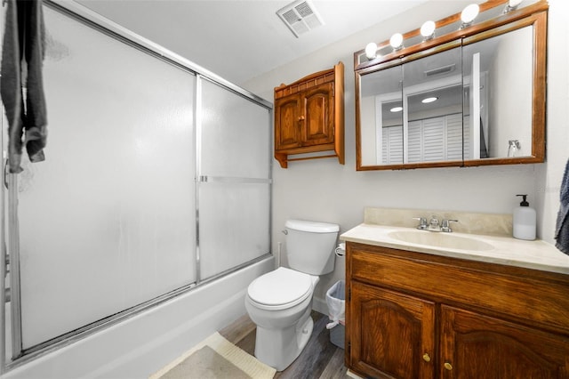 710 N Village Dr N Unit 102, Saint Petersburg, FL 33716 - bathroom with wood finished floors, toilet, vanity, and enclosed tub / shower combo