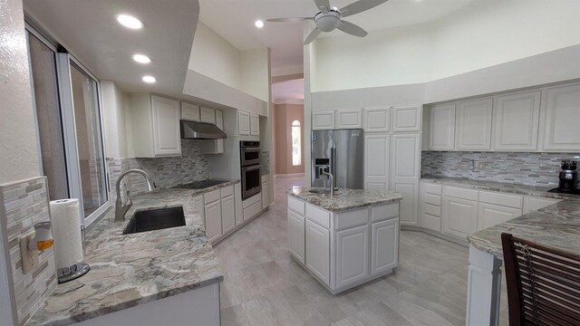 4872 Silverthorne Ct, Oldsmar, FL 34677 - kitchen featuring a sink, stainless steel appliances, tasteful backsplash, ceiling fan, and light stone counters