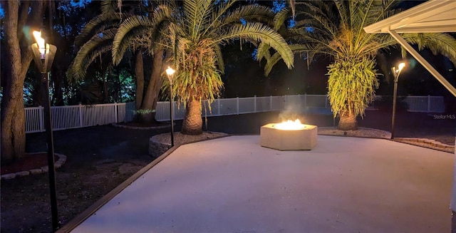 4872 Silverthorne Ct, Oldsmar, FL 34677 - patio at night with an outdoor fire pit, a patio, and a fenced backyard