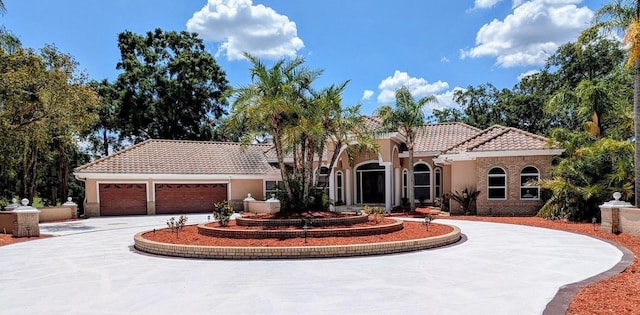 4872 Silverthorne Ct, Oldsmar, FL 34677 - mediterranean / spanish-style house with curved driveway, a tile roof, an attached garage, and stucco siding