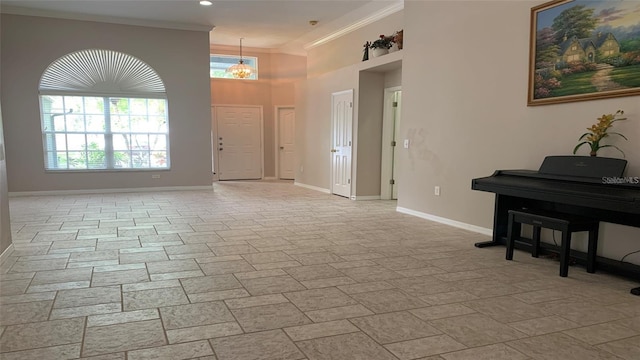 entryway with baseboards, ornamental molding, and a towering ceiling