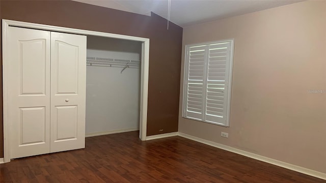 unfurnished bedroom with baseboards, wood finished floors, and a closet