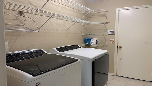 washroom with laundry area, light tile patterned floors, and washing machine and clothes dryer