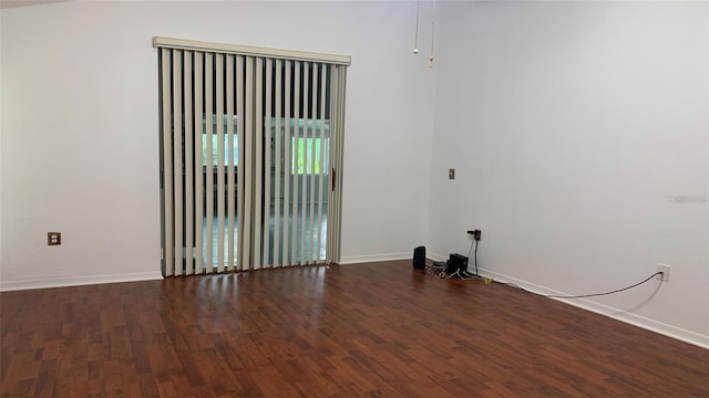 empty room featuring baseboards and wood finished floors