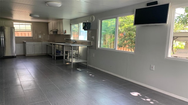 kitchen with a healthy amount of sunlight, baseboards, and freestanding refrigerator