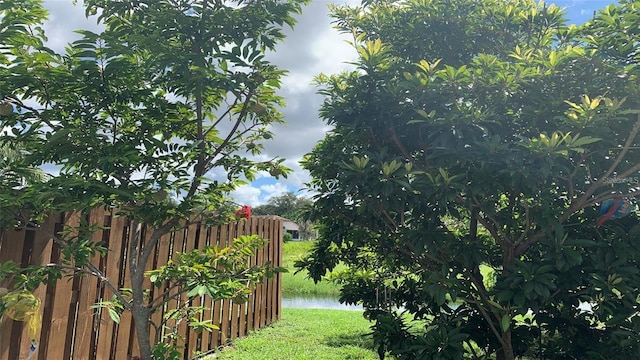 view of yard featuring fence and a water view