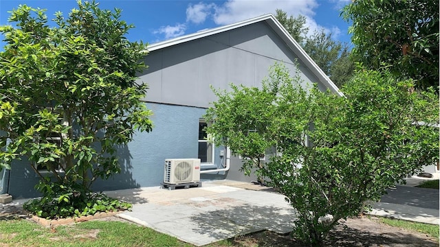 rear view of property with ac unit, a patio area, and stucco siding