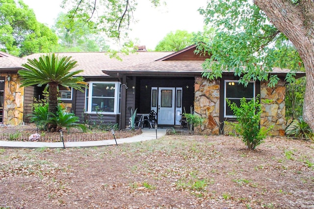 16536 Caldwell Ln, Spring Hill, FL 34610 - ranch-style home with a porch, roof with shingles, and stone siding