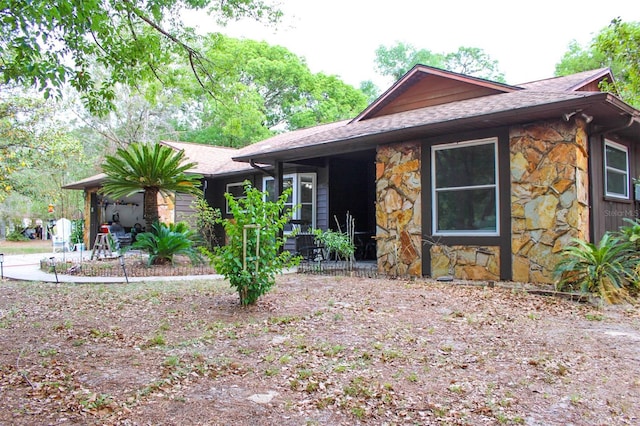 16536 Caldwell Ln, Spring Hill, FL 34610 - view of front of house featuring a patio area, roof with shingles, and stone siding