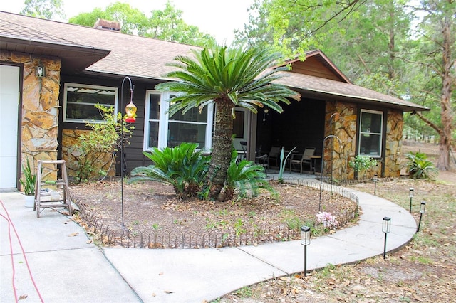 16536 Caldwell Ln, Spring Hill, FL 34610 - view of front of house featuring roof with shingles, a patio area, and stone siding