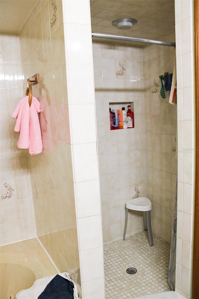 16536 Caldwell Ln, Spring Hill, FL 34610 - full bathroom with a jetted tub, tile patterned flooring, a tile shower, and tile walls