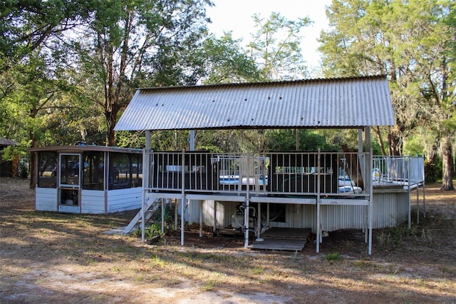 16536 Caldwell Ln, Spring Hill, FL 34610 - back of house with a sunroom, metal roof, a deck, and a carport
