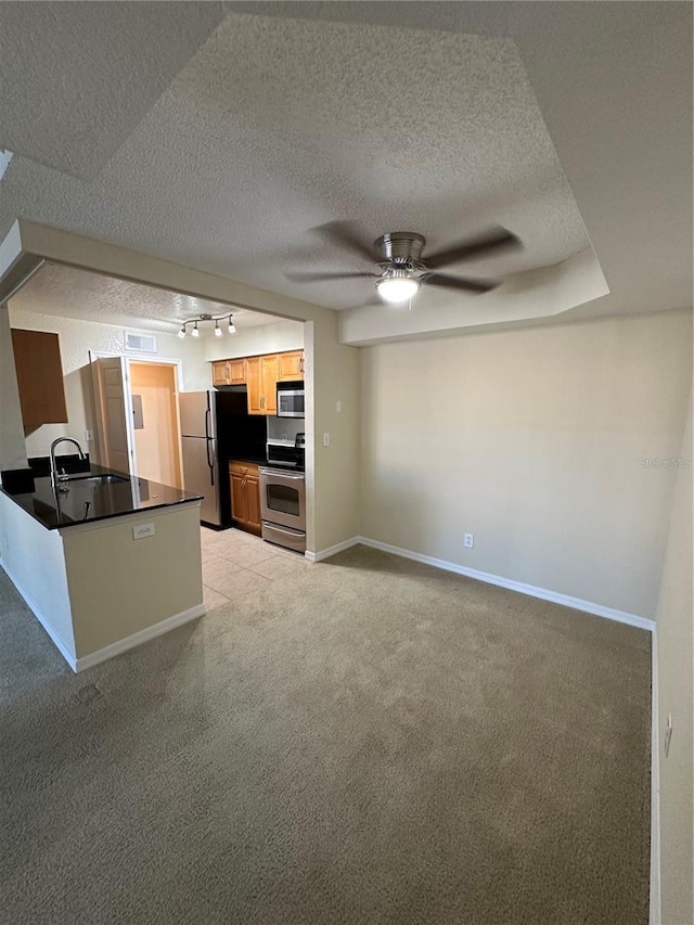 3260 Haviland Ct Unit 202, Palm Harbor, FL 34684 - kitchen featuring ceiling fan, dark countertops, rail lighting, a peninsula, and stainless steel appliances