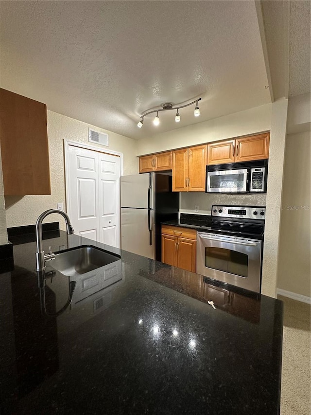3260 Haviland Ct Unit 202, Palm Harbor, FL 34684 - kitchen featuring visible vents, a textured wall, a textured ceiling, a sink, and stainless steel appliances