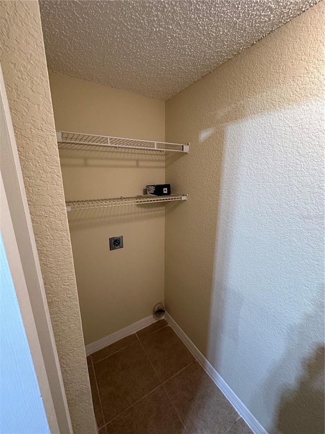 3260 Haviland Ct Unit 202, Palm Harbor, FL 34684 - laundry room featuring laundry area, a textured wall, hookup for an electric dryer, and dark tile patterned flooring
