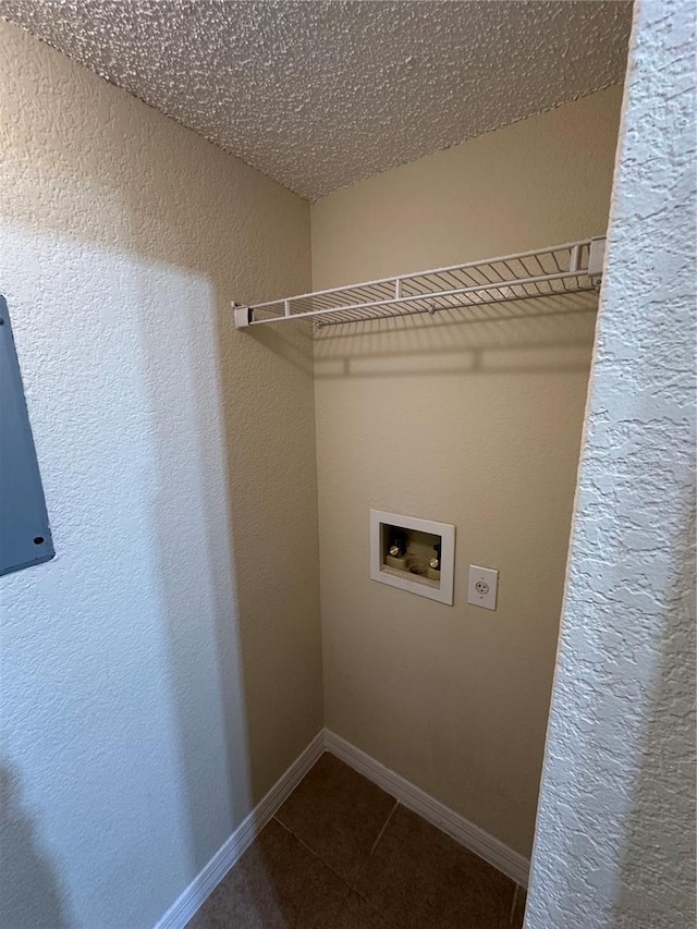 3260 Haviland Ct Unit 202, Palm Harbor, FL 34684 - washroom featuring dark tile patterned floors, hookup for a washing machine, a textured wall, and baseboards