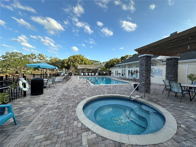 3260 Haviland Ct Unit 202, Palm Harbor, FL 34684 - community pool featuring a patio area, a hot tub, fence, and outdoor dining space