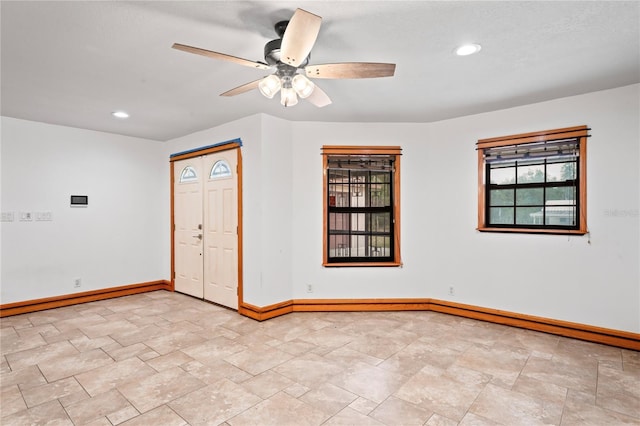 spare room featuring baseboards, a ceiling fan, light stone finish floors, and recessed lighting