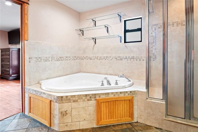 bathroom with a shower stall and a bath