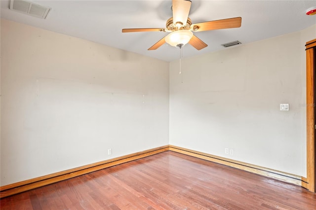 spare room with wood finished floors, ceiling fan, and baseboards
