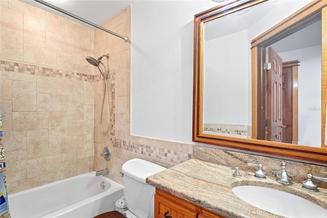 bathroom featuring shower / tub combo, vanity, toilet, and tile walls