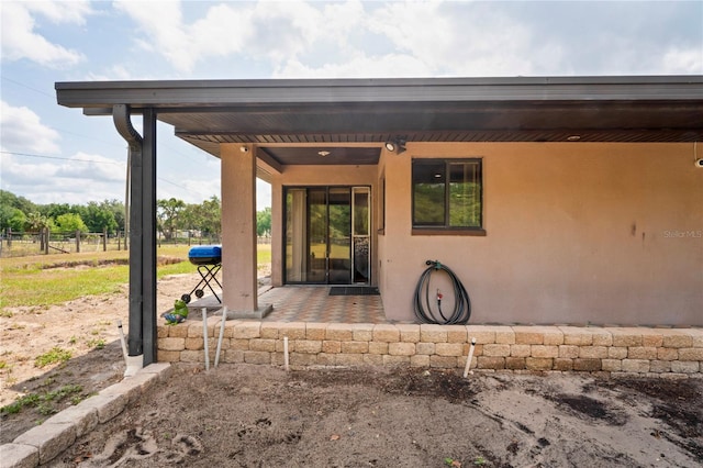 view of exterior entry featuring stucco siding