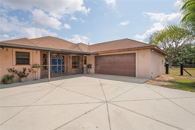single story home featuring stucco siding, an attached garage, fence, driveway, and a shingled roof