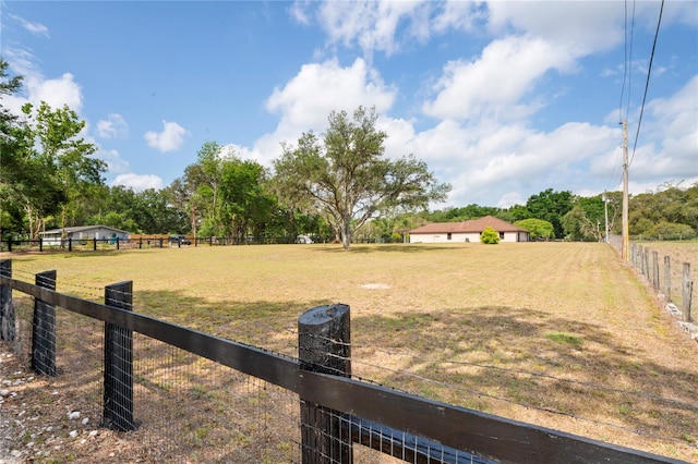 view of yard with fence and a view of rural / pastoral area