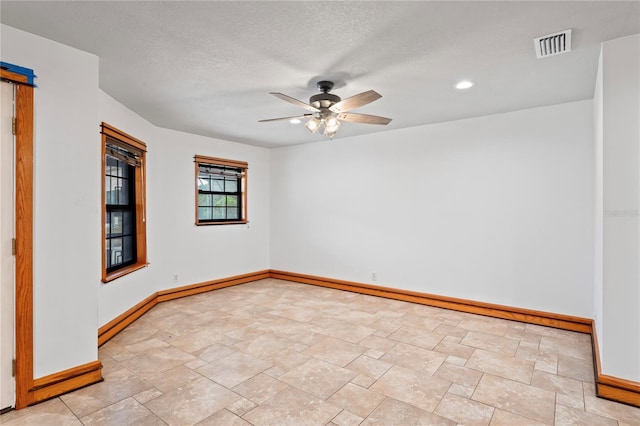 39427 Comstock Ln, Zephyrhills, FL 33540 - empty room with baseboards, a ceiling fan, stone finish floors, recessed lighting, and a textured ceiling
