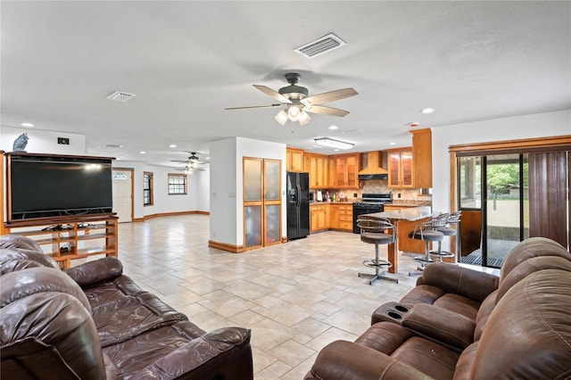 39427 Comstock Ln, Zephyrhills, FL 33540 - living room featuring a ceiling fan, baseboards, recessed lighting, and stone tile flooring