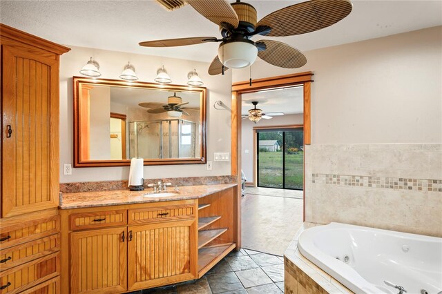 39427 Comstock Ln, Zephyrhills, FL 33540 - bathroom with a ceiling fan, a jetted tub, vanity, and an enclosed shower