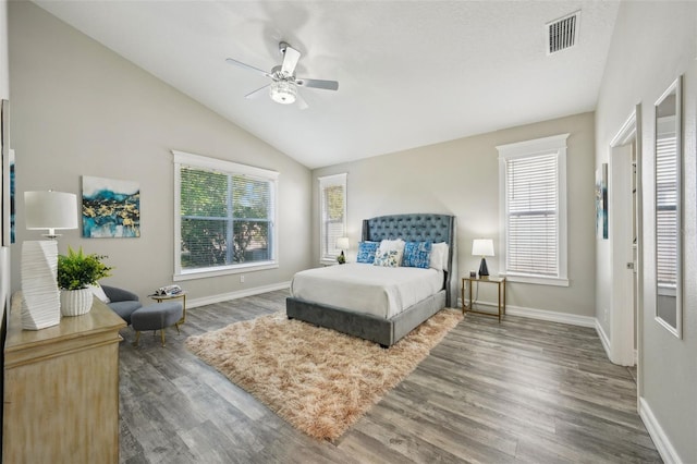 bedroom featuring baseboards, multiple windows, wood finished floors, and visible vents