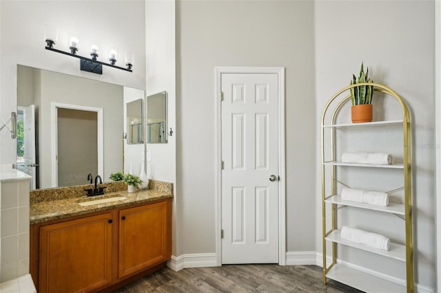 bathroom featuring vanity, baseboards, and wood finished floors