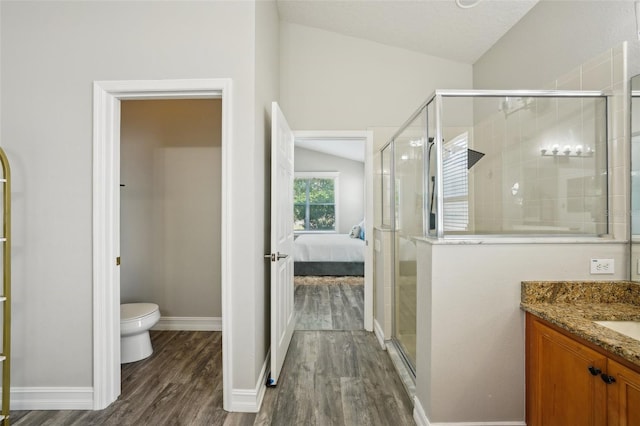 full bath featuring connected bathroom, toilet, a shower stall, wood finished floors, and vaulted ceiling