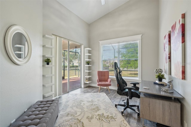 office area featuring baseboards, wood finished floors, and high vaulted ceiling