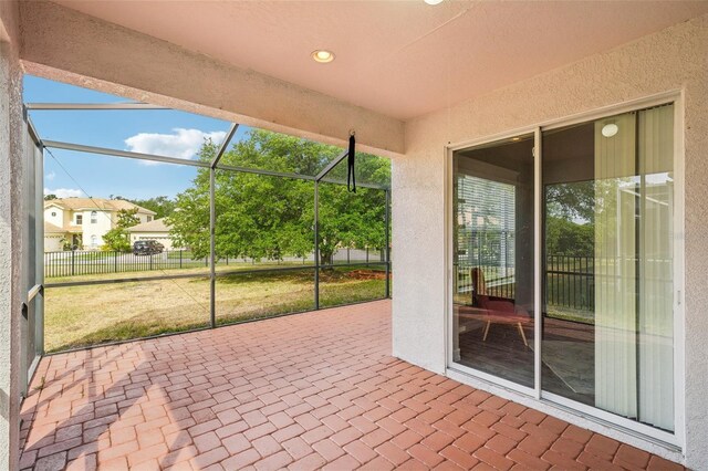 view of patio featuring glass enclosure