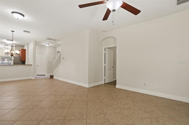 20221 Vintage Oaks Pl, Tampa, FL 33647 - empty room featuring light tile patterned floors, a ceiling fan, a chandelier, stairway, and arched walkways