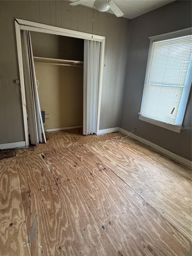 unfurnished bedroom featuring baseboards, ceiling fan, and a closet