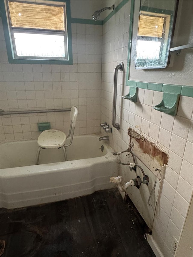full bath with tile walls and washtub / shower combination